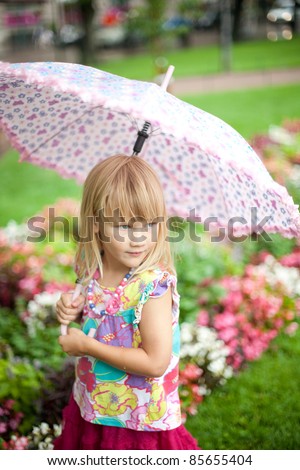 Little girl with a pink umbrella on a rainy day in Helsinki, Finland