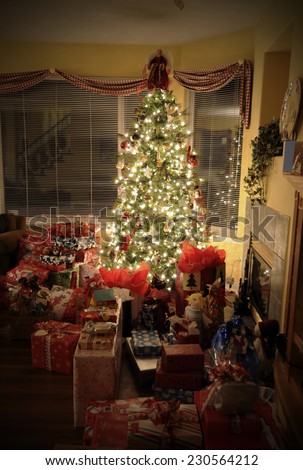christmas tree with gifts / all up in the living room / lighting up the dark