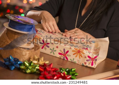 woman wrapping gifts / looks like they are for christmas / judging by decor