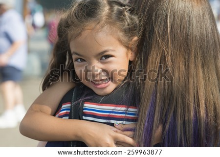 happy girl hugs mom / because that's what little kids / they just like to do