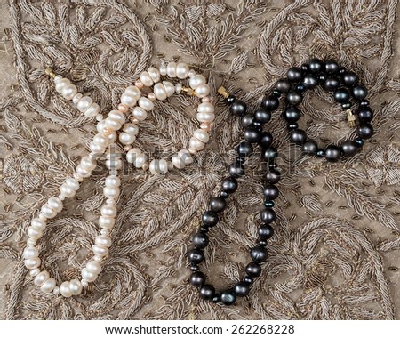 Bead of white and black pearls from India .