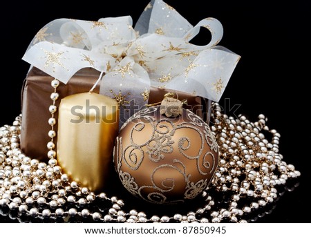 christmas gift in gold box with bow and candle