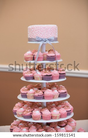 Tower of Cupcakes with a Pink Wedding Cake