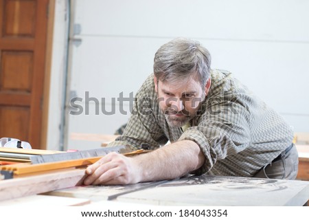 Male carpenter using table saw for cutting wood