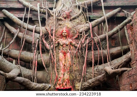 Idols of Hindu Goddess Durga and lord shiva carved out of a huge banyan tree