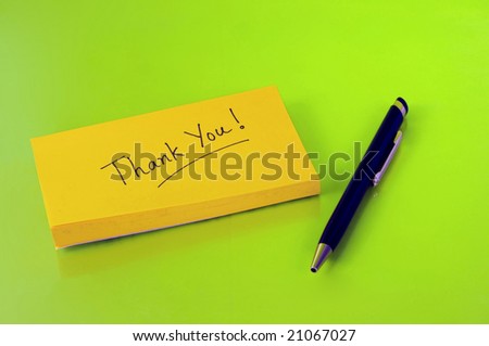 Thank you note on a post-it with pen on green background
