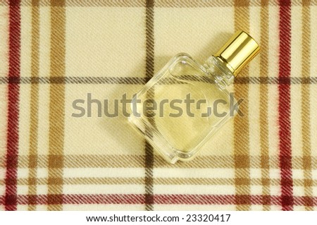 bottle of cologne on colorful checkered pattern with plenty of copyspace for advertising text