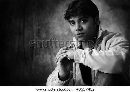 Dramatic portrait of a handsome young man in black and white wearing stylish urban clothing