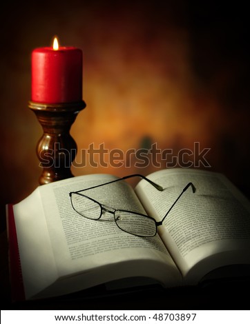 Reading book under light of a candle