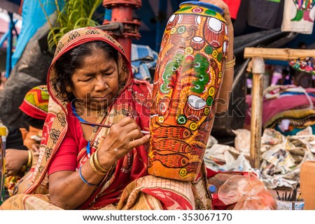 KOLKATA, INDIA - NOVEMBER 28: An Indian elderly craftswoman paints on colorful handicraft items for sale during the annual State Handicrafts Expo 2015 on November 28,2015 in Kolkata,West Bengal,India