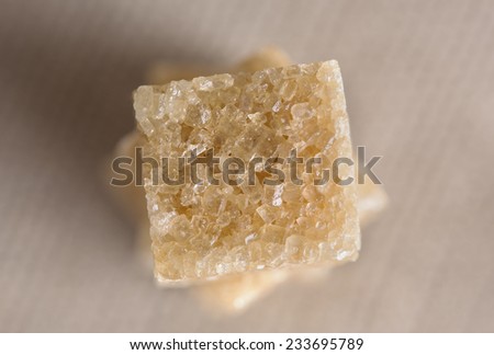 Pieces of brown sugar on light gray-beige background