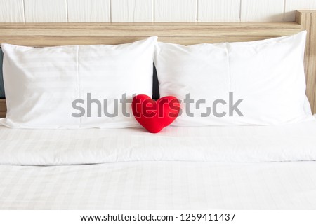 Red heart and Couple white pillow on the bed for love, wedding and valentine\'s day concept