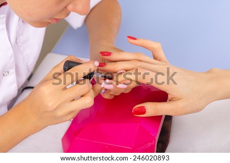 step of manicure process: nail covering with nail gel polish