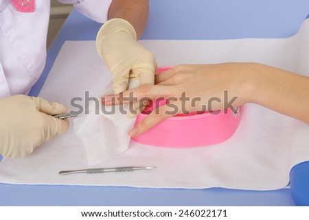 step of manicure process: nails and cuticles shaping with manicure tools