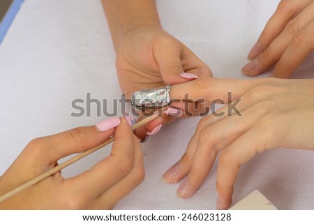 step of manicure process: nail gel polish removal using foil pieces