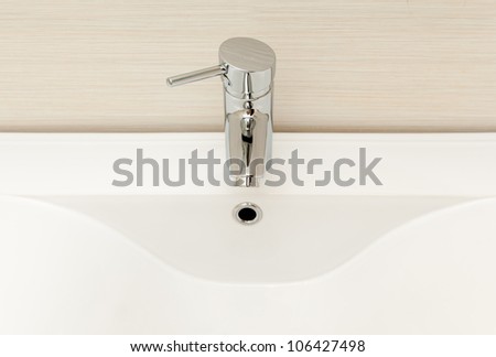 Modern tap with white ceramic sink.