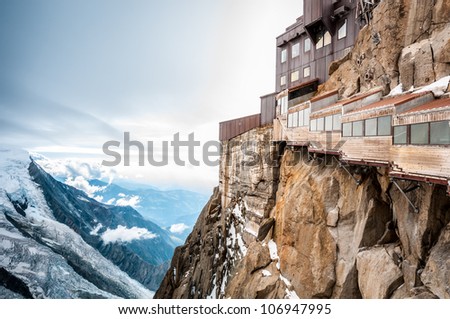View of the Alps from Aiguille du Midi mountain in the Mont Blanc massif in the French Alps. Summit tourist station in foreground. Alps, France, Europe.