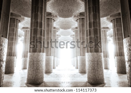Columns and ceiling made of stone and tiles. Beautiful place with colonnade filled with bright sunlight. Building with colonnade. Old temple or palace.