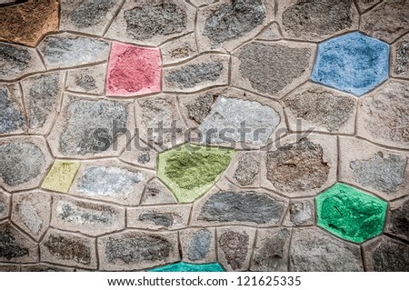 Solid grey stone wall with blocks of different colors. Grunge wall abstract background. Creative bright and colorful design. Mosaic ornament. Stone texture wallpaper.