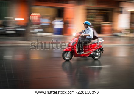 HANOI, VIETNAM - DECEMBER 7: Man in rain riding scooter. Most popular means of transport. Vietnam takes world 4th place in bike usage. December 7, 2012, Hanoi, Vietnam, Asia.