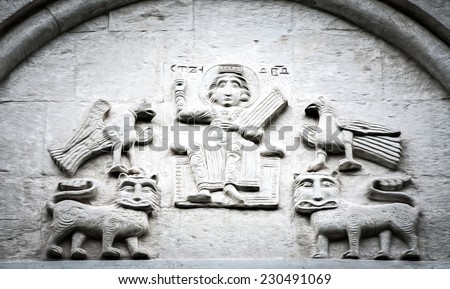 Big wall in church showing five fictional characters. Two birds on top of two lions, sitting man in middle. Primitive stone carving. Beautiful architecture of religious place. Tourist destination.