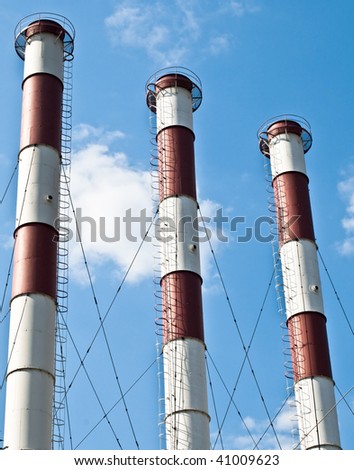 three factory pipe with blue cloudy sky in background