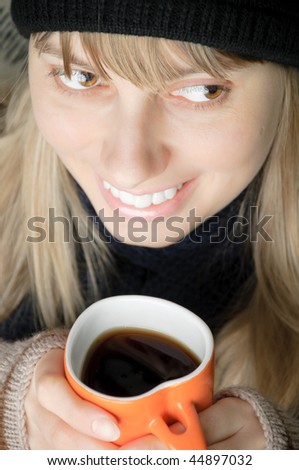 young beautiful woman in winter clothes with orange cup of beverage