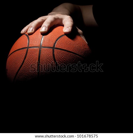 fragment of a basketball ball in a hand of the basketball player