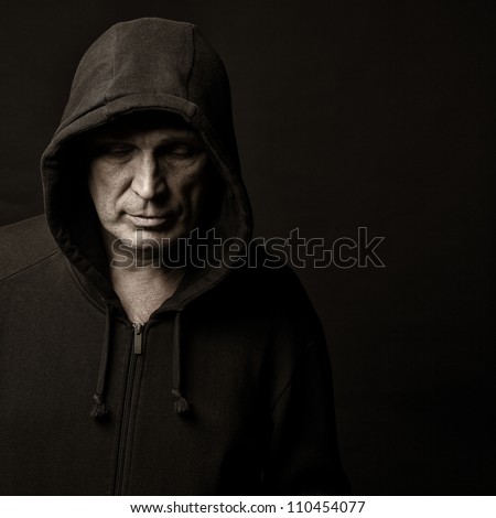 Portrait of the man in a hood against a dark background