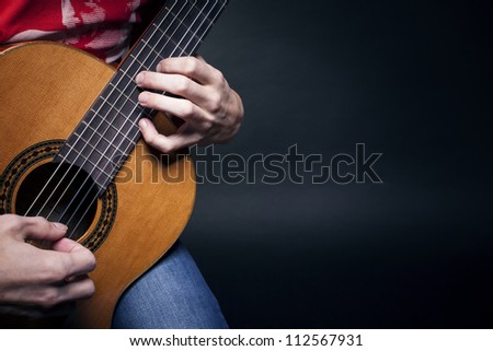 Young man playing the guitar.Guitarist hands in the foreground