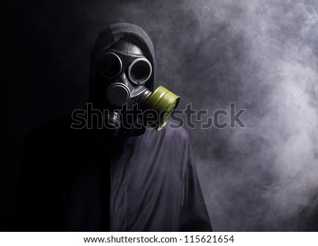 A man in a gas mask in the smoke. black background