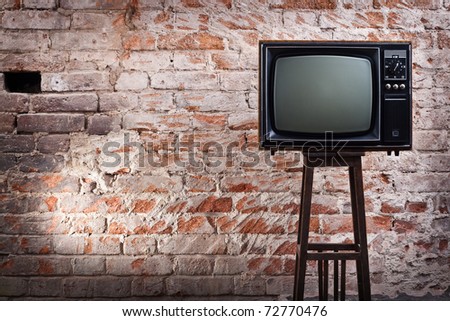 The old TV set against an old brick wall