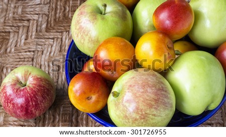 Fresh fruits: apples and plums on the plate