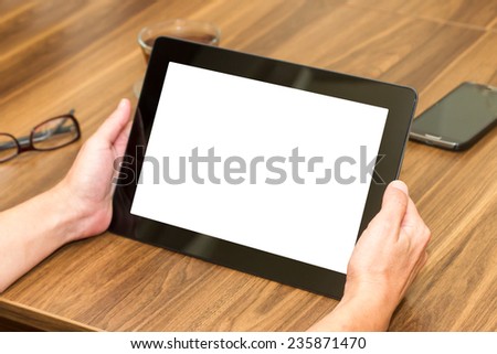 Front view of woman hand holding tablet with blank, white screen.
