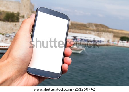 Hand holding and showing smart phone mock up with blank white screen with copy space on travel.
