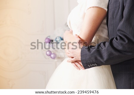Man and woman holding each other\'s hands. Bride and groom on the background of a New Year\'s interior room. Hands close up. Christmas Festive concept for the original wedding day. Happy New Year.