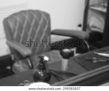 Blurred image - Workplace of the hairdresser. Grooming the beard. Barbershop. Barber tools. Workplace barbershop, vintage armchair. Tools for shaving and straight razors on a barbers table.