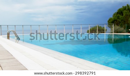 Blurred image of a beachfront swimming pool at the end of the bathing season against the evening sky. Blurring background.