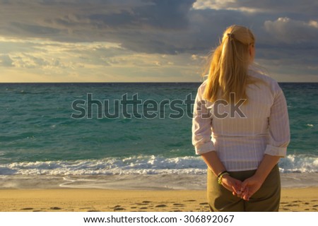 Blurred people on the sunset. Blurred image of people. See the sea. Standing on the beach or ocean view in the distance. Image for background or screen saver. Woman stand back on the sea background.