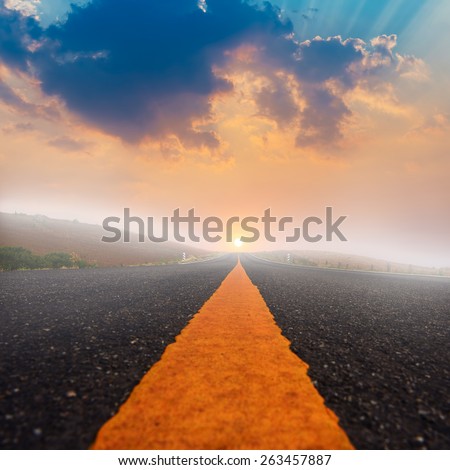Long road and sunset with sun rays.