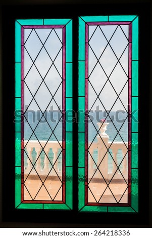 Seaview through the stained-glass window. Sea view of the sea through a beautiful stained glass window on a sunny day