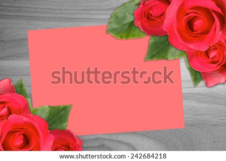 Red roses with the red card on wood background.