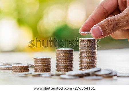 Hand putting money coin stack growing business, Saving money concept