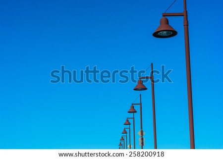 Row of street lights against the blue sky