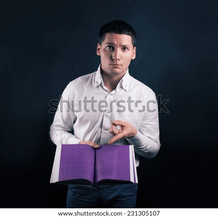 Young man points a finger at the paper book