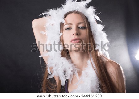 portrait of a young girl with a white boa on a dark background