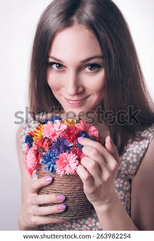 Pretty sweet young brunette girl with expressive eyes holding handmade colorful bouquet of flowers from paper isolated on white. tenderness. youth. gift. surprise. emotion.