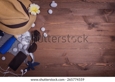things on a dark wooden table background. vacation in the south. pebbles, stones. beach accessories. swimsuit, mask and snorkel diving, Sunglasses, sunscreen, phone, headphones. listen to music, relax