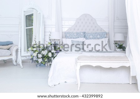 bright, clean stylish interior bedroom and living room with a large panoramic window. beautiful rich antique furniture. four-poster bed, a mirror and a sofa