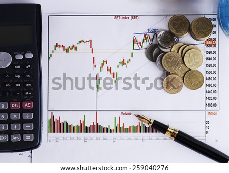 Fountain pen and calculator and coins stack on Stock index chart for finance concept